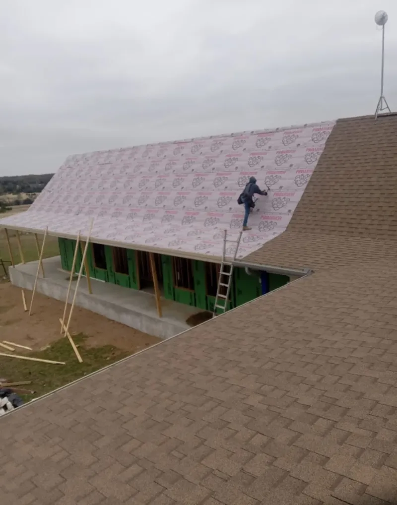 Worker preparing underlayment for a metal roof installation in Bloomsburg